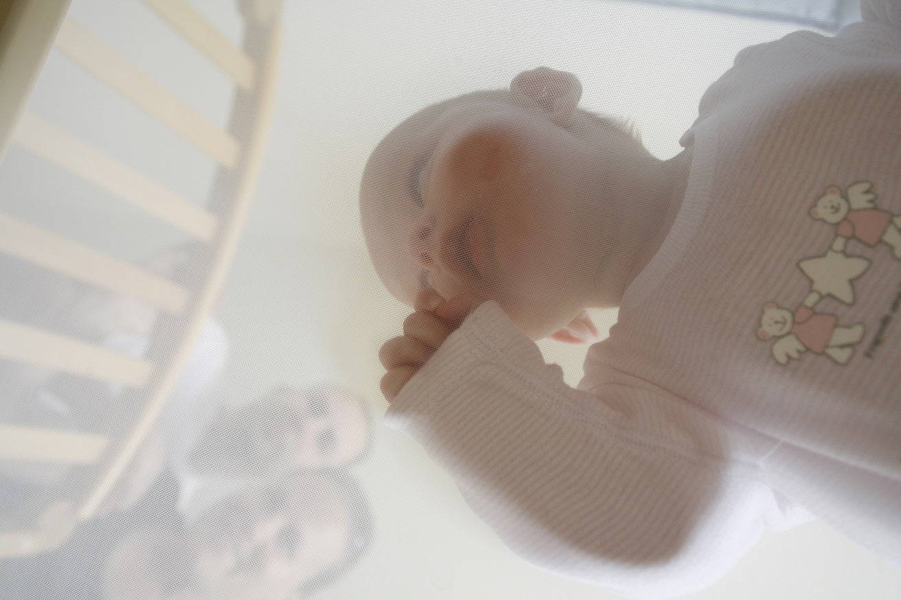 Baby is laying on Numu cot mattress